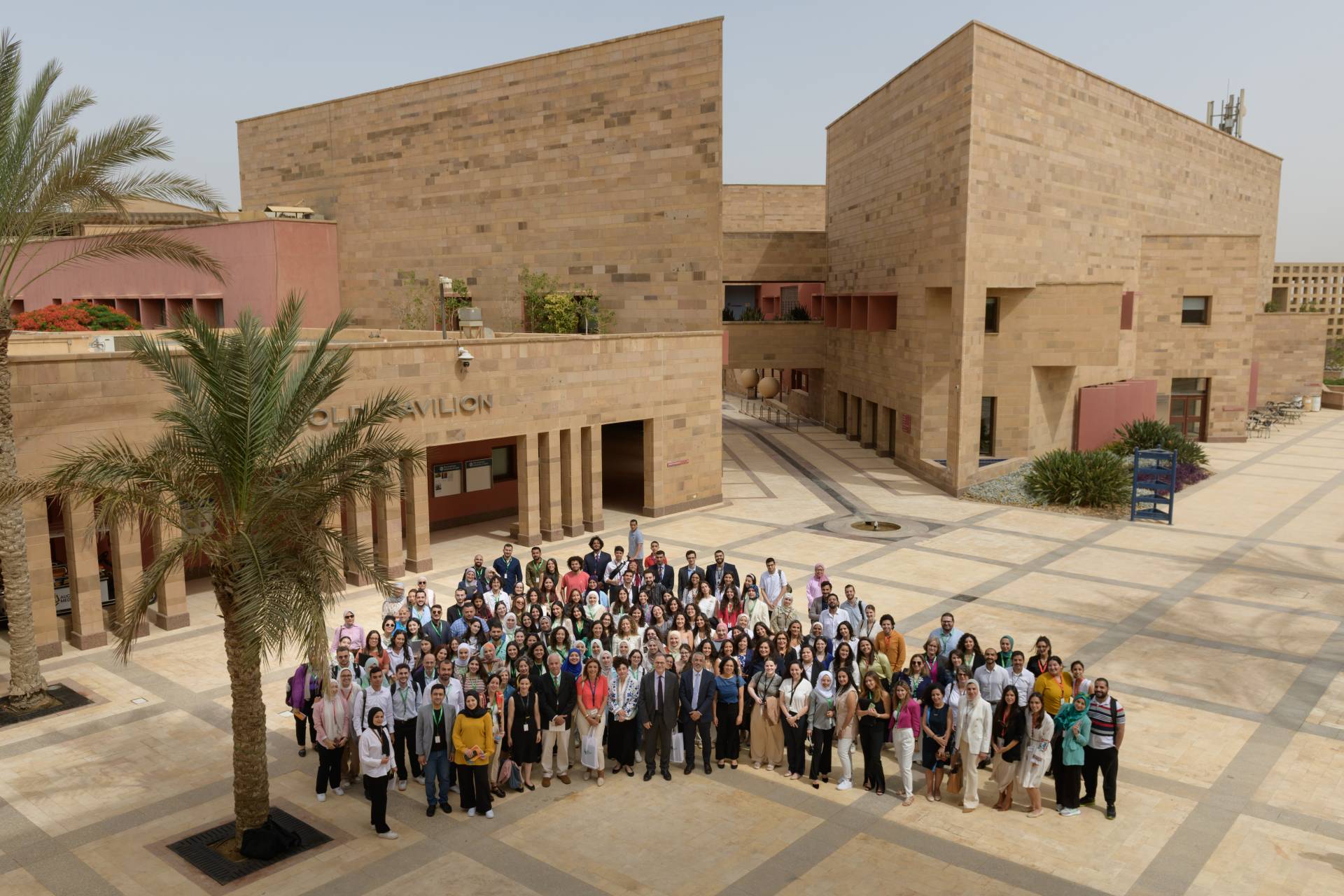 Large group of students standing outside of educational institution.